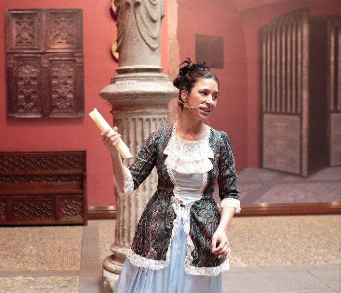 Actriz caracterizada con traje de época durante una visita teatralizada en un espacio histórico y cultural.